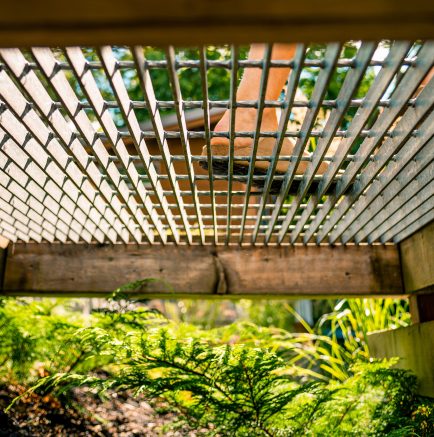 Vue de dessous d'un sentier de caillebotis avec une personne qui marche