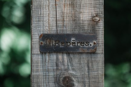 Enseigne de métal Repères sur poutre de bois grise